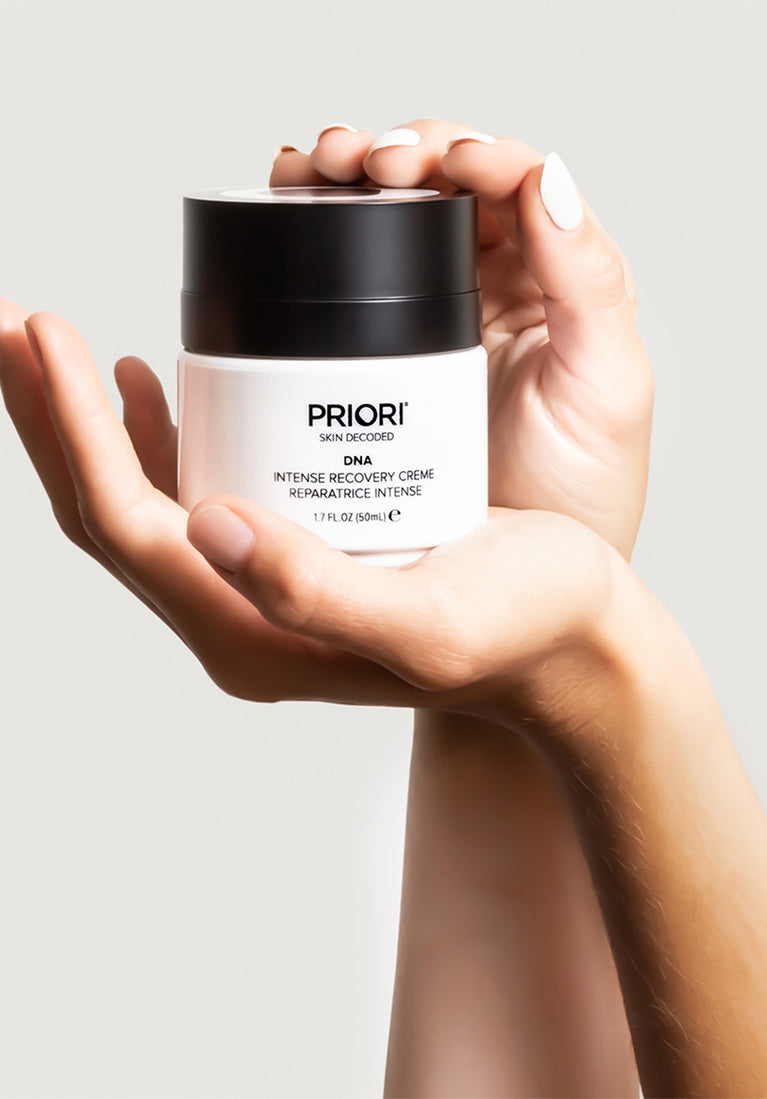 PRIORI DNA Intense Recover Moisturizing Cream pump in hands on a cream background