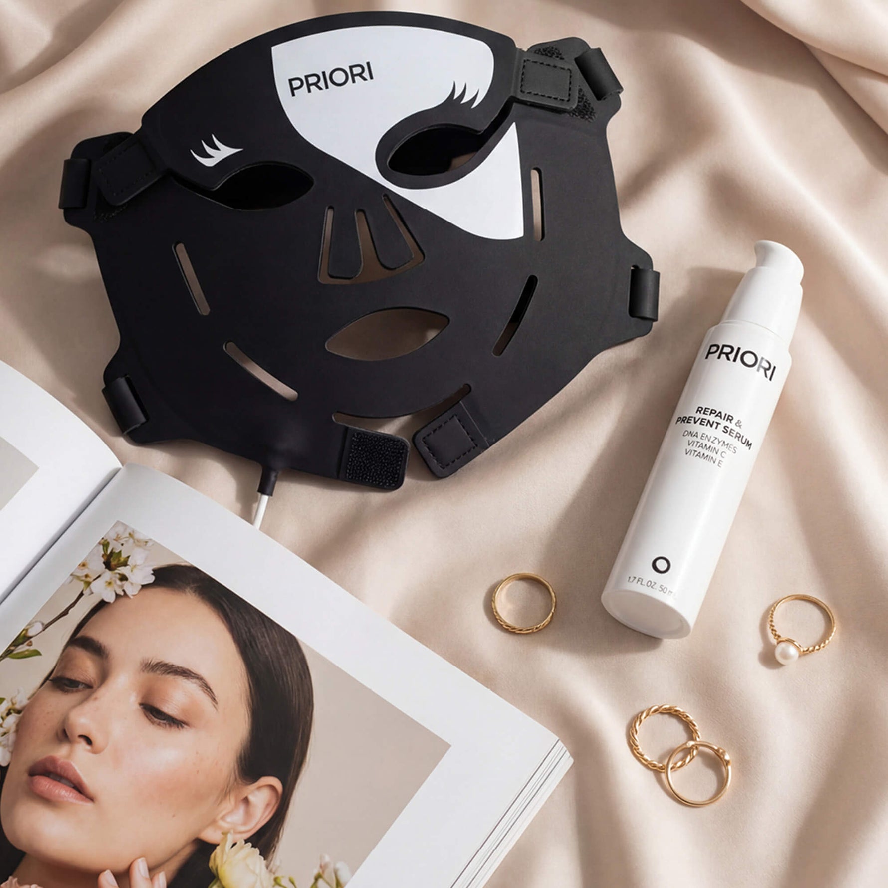 PRIORI Unveiled Red Light LED Face Mask in a bedroom setting paired with DNA Repair and Prevent Serum for best results 