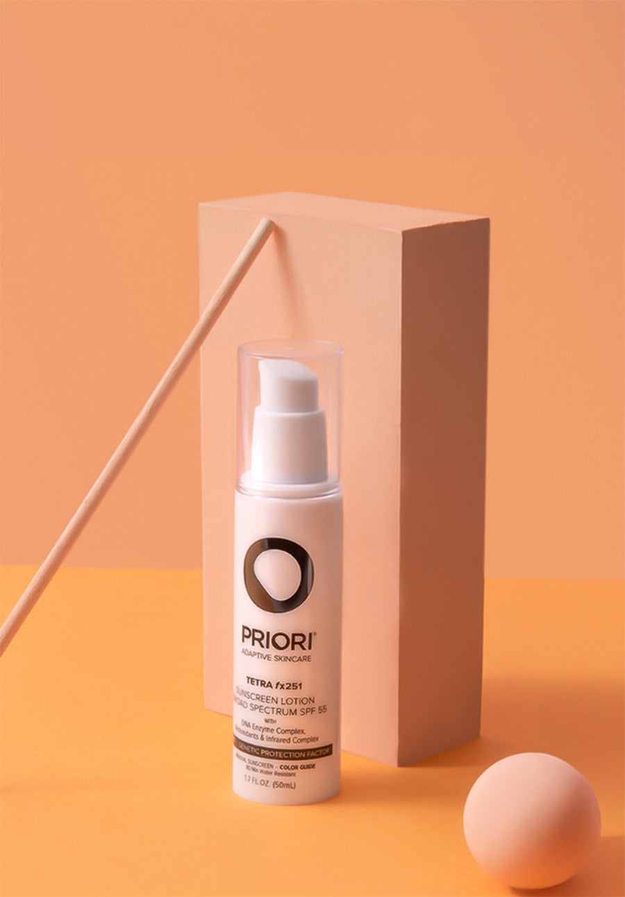 PRIORI Skincare Tetra SPF 55 Mineral Sunscreen lotion bottle with applicator and ball on an orange background