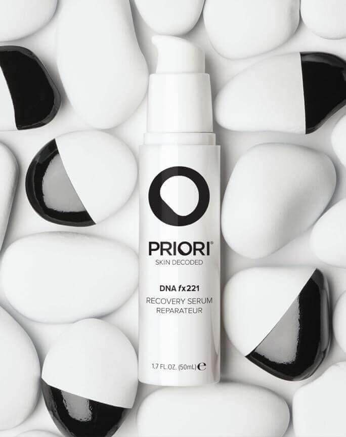 PRIORI DNA Recovery Face Serum Product amongst white and black rocks